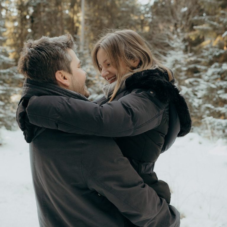 Paar Fotoshooting Lachendes Paar bei Sonnenschein in einem Sonnenblumenfeld